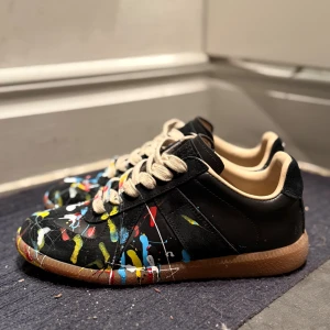 Svarta sneakers med färgstänk - Maison margiella paint splatter skor, helt nya strlk 38/39. Box medföljer samt alla orginala dustbags etc.  Priset är inte helt stucket i sten!