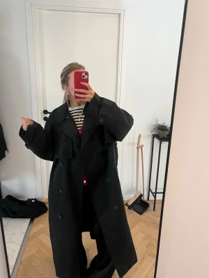 Svart oversized trenchcoat - svart oversized kappa från hm(tror inte den säljs längre). säljer då jag har köpt annan men den är knappt använd så som ny. lappen är kvar så vet tyvärr inte storleken men den är oversized för mig o är 160. skriv vid frågor!