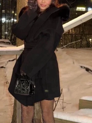 Svart kappa med päls - Säljer en svart kappa med breda ärmar och stor krage med pälsdetalj. Jackan har ett bälte i midjan för snygg passform och är perfekt för kalla dagar. Stilren och elegant look som funkar till många outfits. Vid snabb affär kan pris diskuteras .