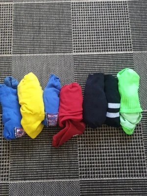 Färgglada sportstrumpor Adidas & Leavanny - Säljer ett paket med sju par sportstrumpor i olika färger från Adidas och Leavanny. Strumporna är i blått, gult, rött, grönt och svart, vissa med logga och detaljer. Perfekta för dig som gillar färg och sportig stil.