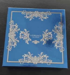 Versace  - Äkta tom ask/kartong från Versace ( innehöll parfym sett) Vackert blåskimrande med text och dekorationer i guld 19 x 19 x 6,5 cm Köpt i Paris Perfekt för samlare eller förvaring Asken är i nyskick