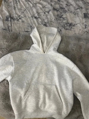 Ljusgrå hoodie med känguruficka - Mycket bra skick, men den har smink i kragen på insidan av tröjan