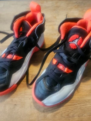 Svarta och röda Air Jordan sneakers - Säljer ett par snygga Air Jordan sneakers i svart, vitt och rött. Skorna har högt skaft, klassisk Jumpman-logga på plösen och röd sula med AIR-detalj. Ovandelen är i läder och textil, med coola kontrastdetaljer och vadderad insida för extra komfort.