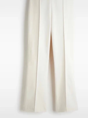 Vida vita kostymbyxor med pressveck - Snygga kostymbyxor i vitt med vida ben och markerade pressveck framtill. Byxorna har hög midja och stilren design, perfekta för en clean och modern look. Materialet ser ut att vara en mjuk och lätt vävd kvalitet.