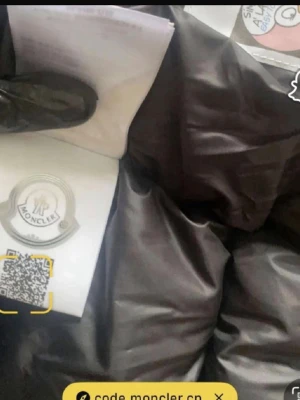 Svart dunjacka från Moncler - Säljer en svart dunjacka från Moncler med glansig yta och klassiska Moncler-loggor på insidan. Jackan har quiltad design och är tillverkad i polyester, perfekt för kalla vinterdagar. Långärmad modell med exklusiva detaljer.