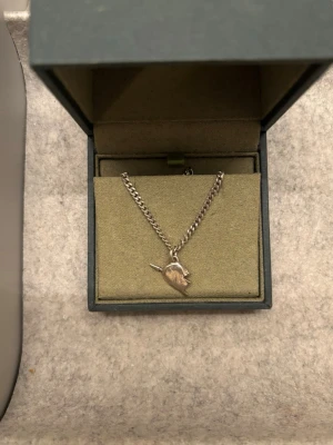 Maria Nilsdotter halsband halvhjärta - Maria Nilsdotter halsband halvhjärtat! Använt men fortfarande i väldigt fint skick. Tror det är längd 45cm 