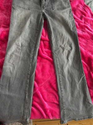 Grå raka jeans från 157 - Säljer ett par grå jeans från 157 med raka ben och hög midja. Jeansen har stora framfickor och stängs med knapp och dragkedja. Materialet är klassisk denim i bomull och färgen är snyggt tvättad grå. Perfekta till en avslappnad stil. Säljer pågrund av de är för stora och används inte längre! Jeansen är använda en par gånger men det inget som syns eller märks på själva jeansen