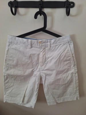 Vita Polo horts från Ralph Lauren - Snygga vita shorts i klassisk modell med normal passform. Tillverkade i mjuk bomull med lite stretch för extra komfort. Shortsen har sidofickor och bälteshällor, perfekta för en clean och fräsch sommarlook.