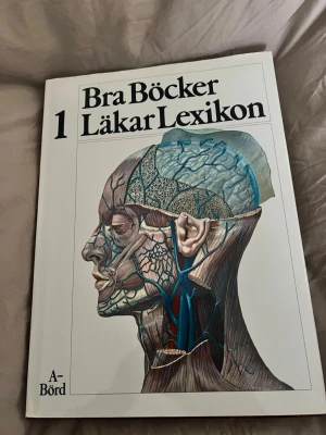 Bra Böcker Läkar Lexikon band 1 & 6 - Två volymer av Läkar Lexikon från Bra Böcker, band 1 (A-Börd) och band 3 (G-Kö). Böckerna har vita hårda pärmar med detaljerad anatomisk illustration av människans huvud i profil på omslaget. Perfekt för dig som gillar medicin och vill lära dig mer om kroppen.