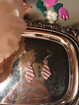 Slips örhängen - Handgjorda örhängen med slipsar. Schimriga slipsar med ränder. One of a kind Denna är Handgjord av lera därav priset. Om intresse fins kan jag göra flera