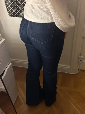 Mörkblå bootcut jeans - Säljer ett par mörkblå bootcut jeans som är midwaist. De är använda ett fåtal gånger men visar inga tecken på användning. Sitter perfekt och formar kroppen på ett fint sätt. Pris går att diskutera vid snabb affär 🌸