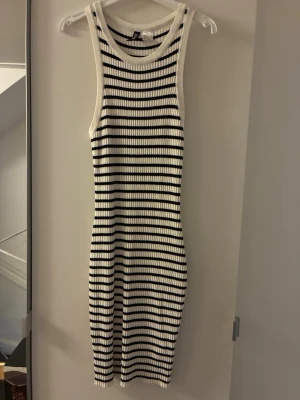 Randig ribbad klänning H&M - Säljer en ribbad, ärmlös klänning från H&M med svartvita horisontella ränder. Klänningen är figurnära och har en rund halsringning. Storlek S🩷
