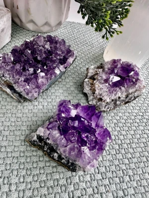 3 st ametist kluster från Uruguay  - 3 ametistkluster från Uruguay.   Ametist är känd för sina lugnande och balanserande energier och används ofta för meditation, vila och skydd mot stress.  310 gram totalt.   De är 5, 6.5 och 7 cm långa.  