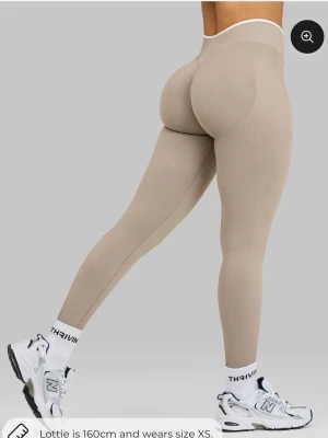 Beige seamless leggings med hög midja - Säljer ett par beige seamless leggings med hög/midwaist midja och ribbade detaljer. De har scrunch-effekt bak för att framhäva formerna och är tillverkade i ett stretchigt, mjukt material som sitter tight. Perfekta för gymmet eller chill dagar. Helt nya, då dem inte var rätt storlek för mig