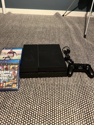 PlayStation 4 med spel och handkontroll - Säljer en svart PlayStation 4 med en matchande svart DualShock 4-handkontroll och strömkabel. Medföljer flera PS4-spel, bland annat GTA V, FIFA 15, Battlefield 4 och Watch Dogs. Perfekt för dig som vill ha en komplett spelsetup direkt.