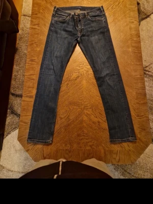 Mörkblå raka jeans - Snygga mörkblå jeans med rak passform och klassisk femficksdesign. Jeansen har normal midja och stängs med dragkedja och knapp. Perfekta för en avslappnad och stilren look.