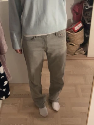 Grå raka jeans från ginatricot - Säljer ett par grå jeans från ginatricot med rak passform och klassisk femficksdesign. Jeansen har normal midja och är tillverkade i ett mjukt bomullsmaterial. Perfekta för en avslappnad och stilren look.