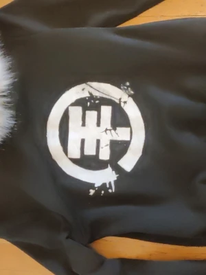 Tokio hotel fur hoodie - Svart hoodie med dragkedja och vit fuskpäls runt huvan. På ryggen är det en tokio hotel logo som jag gjort själved textil färg så det kommer troligtvis inte gå bort om man tvättar den rätt! Passar som en S-M ungefär