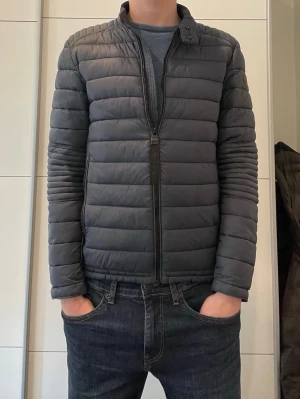 Mörkgrå pufferjacka från Replay - Snygg mörkgrå pufferjacka från Replay i storlek XS. Perfekta jackan till våren i väldigt bra skick. 