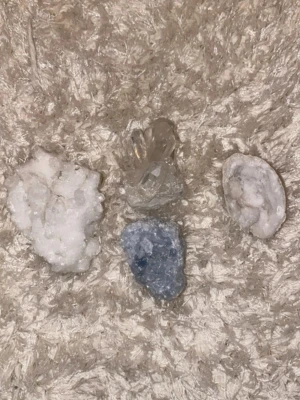 Samling av kristaller och mineraler - Fyra olika kristaller och mineraler säljes tillsammans. Innehåller en vit kluster, en klar kvarts med flera spetsar, en blåaktig sten och en vit geodliknande sten. Perfekt för dig som gillar kristaller, dekoration eller samling.