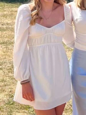 Vit kort klänning med puffärm - Vit klänning med långärmar. Använd en gång. Perfekt till skolavslutning eller student. Ifrån Bershka i storlek xs. 