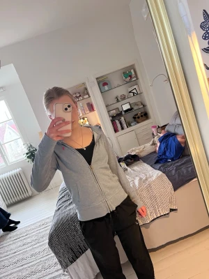 Grå hoodie från Polo Ralph Lauren - Snygg ljusblå  hoodie från Polo Ralph Lauren med dragkedja och huva. Klassisk rosa logga broderad på bröstet. Tillverkad i mjukt bomullsmaterial som känns skönt mot huden. Perfekt för en avslappnad och stilren look.