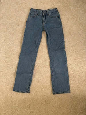 Blå raka jeans  - Ett par blå raka low waist jeans från Never Denim i storlek W26 L32. Jättefina och i väldigt bra skick.
