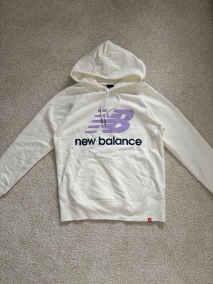 Vit hoodie från New Balance - En vit New Balance hoodie i storlek S. Den är knappt använd därför som ny.
