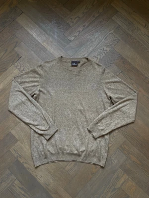 Beige stickad tröja Oscar Jacobson - Säljer en stilren beige stickad tröja från Oscar Jacobson. Tröjan har rund halsringning, långa ärmar och är tillverkad i Italien. Materialet är mjukt och tunt, perfekt för lager på lager och en clean look. Storlek S