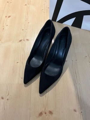 Svarta klackskor med spets  - Snygga klackskor från H&M i storlek 38, klacken är 6,5 cm. Perfekt för speciella tillfällen. Använt en gång och är som ny