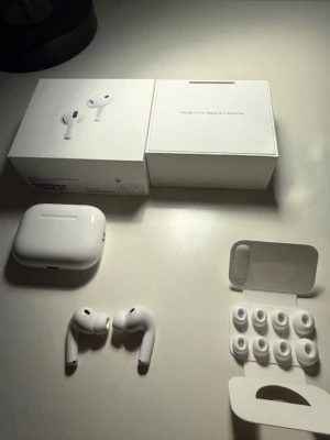 Apple AirPods Pro med laddningsetui - Säljer ett par vita Apple AirPods Pro med laddningsetui och flera extra silikonpluggar. Trådlösa in-ear hörlurar med stilren design i blank plast och smart passform. Perfekta för dig som vill ha grymt ljud och smidig anslutning till din iPhone.