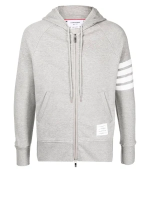 Grå hoodie med dragkedja Thom Browne - Snygg grå hoodie från Thom Browne med dragkedja framtill, justerbar huva och vita signaturränder på ena ärmen. Tillverkad i mjuk bomullsmix och har kängurufickor samt en liten logolapp nedtill. Perfekt för en avslappnad och trendig look.  Låt mig veta om du vill ha fler bilder. Skriv om man ör intresserad ;) KVITTO FINNS!
