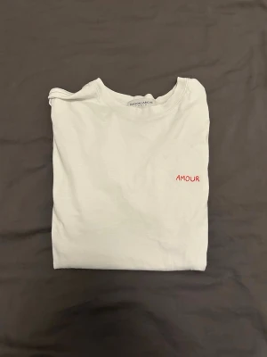 Vit T-shirt  - Vit T-Shirt från Maison Labiche Paris med ”Amour” broderat på bröstet. Riktigt snygg nu till sommaren.