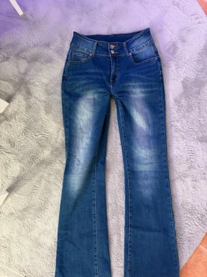 Blå bootcut jeans med slitningar - ”Kvarg” jeans med slitna detaljer på bakfickorna. Har sydd de så de är blir lägre midja. 