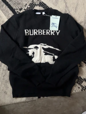 Burberry sweatshirt  - En svart snygg burberry sweatshirt perfekt för våren och sommaren eftersom den är ganska tunn, storleken är M men skulle nog säga att den passar S också. Fick den i present men den är värd 11 000 hos burberry hemisdan.