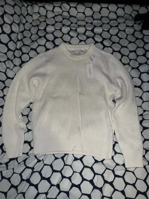 Vit ribbstickad tröja från Selected - Säljer en stilren vit ribbstickad tröja från Selected. Tröjan har rund halsringning, långa ärmar och breda muddar vid ärmslut och nederkant. Perfekt för lager på lager och enkel att matcha med olika outfits. Är i storlek XS men passar som M