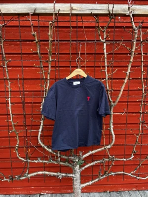 Mörkblå Ami Paris t-shirt  - Stilren mörkblå Ami Paris t-shirt i myvket bra skick! Orginalstorlek S men sitter som en XS. Priset ej hugget i sten. Hör av er vid frågor eller funderingar! 