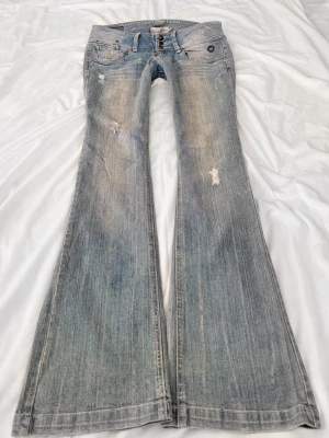 Vintage ljusblå superlågmidjade bootcut jeans - Sååå sjukt snygga vintage superlågmidjade bootcut jeans med slitna detaljer! 