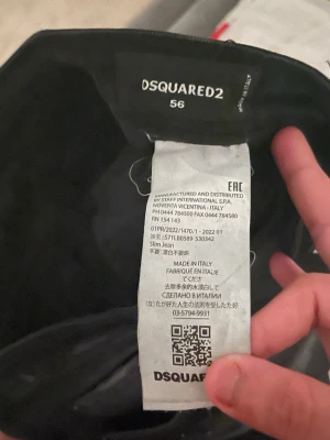 Svarta slim jeans från Dsquared2 - Säljer ett par svarta slim fit jeans från Dsquared2 med coola slitningar och diskreta färgstänk. Jeansen har klassisk femficksmodell och är tillverkade i Italien. Perfekta för dig som vill ha en edgy och modern look.