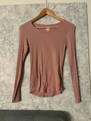 Ljusrosa långärmad topp - En enkel och stilren ljusrosa långärmad topp från hm som sitter tajt och ger en fin figur. Tröjan är använd enstaka gånger och i storlek S 