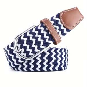 Blåvitt flätat bälte med läderdetaljer - Snyggt flätat bälte i marinblått och vitt med bruna läderdetaljer vid spännet. Bältet har ett klassiskt silverfärgat spänne och passar perfekt till jeans eller chinos för en stilren look.