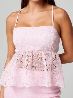 Ljusrosa spetslinnetopp med volang - Supersöt ljusrosa linnetopp med tunna axelband och volang i spets. Toppen har ett romantiskt blommönster och öppen rygg med korsade band. Perfekt för dig som vill ha en feminin och trendig look. Ny, bara testat.