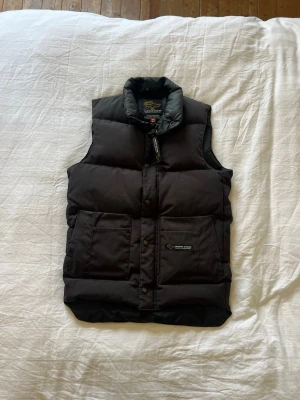 Canada goose väst  - Säljer denna Canada goose västen i svart färg, väldigt fet är och borde passa för runt 168 cm typ då det är en xs! Inte ny !        Produkt nummer är 68f8490.