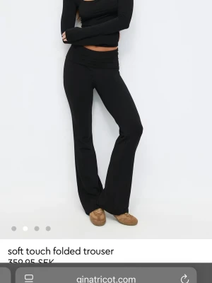 Svarta soft touch leggings Gina Tricot - Säljer ett par svarta leggings från Gina Tricot med mjuk soft touch-känsla och utsvängda ben. De har en bred, vikt linning som ger en snygg siluett och är perfekta för en avslappnad men trendig look. Materialet är stretchigt och följsamt.