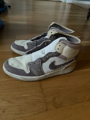 Jordan 1 beige/brun - Säljer ett par Jordan 1 sneakers i beige och brunt. Skorna har en klassisk hög siluett, perforerad tåbox och ikonisk Swoosh på sidan. Materialmix av mocka och textil ger en unik look. Perfekta för dig som gillar streetwear och vill sticka ut. Vid frågor så är det bara att skriva mvh William :)