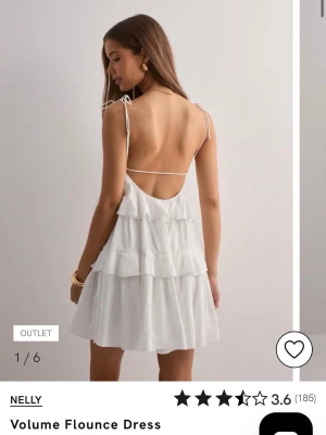 Vit volangklänning från Nelly - Söt vit kortklänning från Nelly med tunna axelband och öppen rygg. Klänningen har flera lager volanger som ger en luftig och flowy känsla. Perfekt för varma dagar och sommarens alla tillfällen. Tillverkad i ett lätt tyg med avslappnad passform. Helt ny med prislapp kvar.
