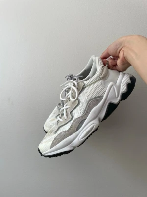 Vita Adidas Ozweego sneakers - Säljer ett par vita Adidas Ozweego sneakers där jag bytt ut skosnöre men som lätt går att byta tillbaka. Supersköna och luftiga skor 