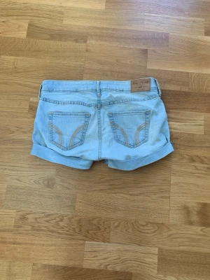 Ljusblå jeansshorts från Hollister - Snygga ljusblå jeansshorts från Hollister med uppvikta benslut. De har sömmar på fickorna och är i storlek xs/s. Materialet är lite stretchigt så ja jag skulle säga att det är något där emellan. Pris kan diskuteras.