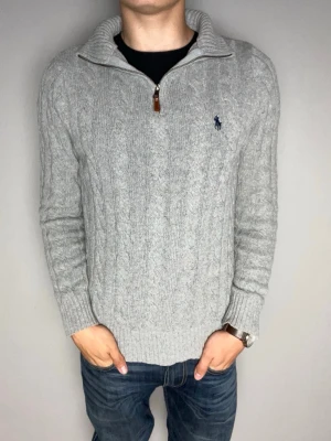 Grå kabelstickad tröja Polo Ralph Lauren - Snygg grå kabelstickad tröja från Polo Ralph Lauren med halv dragkedja och hög krage. Mycket bra skick, bara lite nopprig. Skickar snabbt efter att du har beställt. Frågor? Skicka ett meddelande.