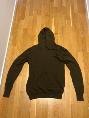 Stickad hoodie - Schyst stickad hoodie från J.Lindeberg i merino ull. Finns ett litet hål på framsidan vid fickan men går nog att laga enkelt. Kontakta mig vid fler frågor!